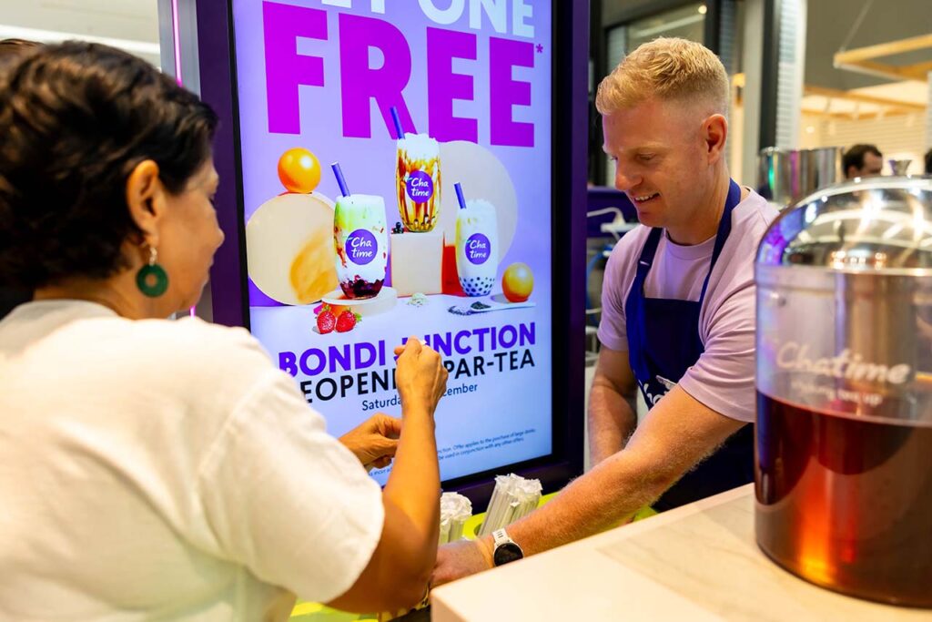 Chatime team member serving a customer during a busy Australian bubble tea store opening
